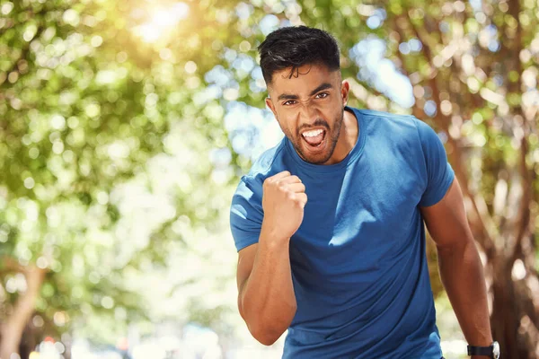 意欲的で勝利に興奮している若い混合レース運動選手の肖像画 公園でフィットネスをしながら運動をしながら喜びを表現するヒスパニック系の男 — ストック写真