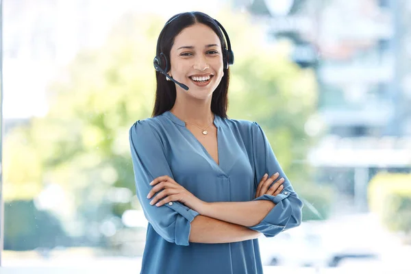 Friendliness is a must-have attribute for call centre agents. Portrait of a young call centre agent standing with her arms crossed in an office