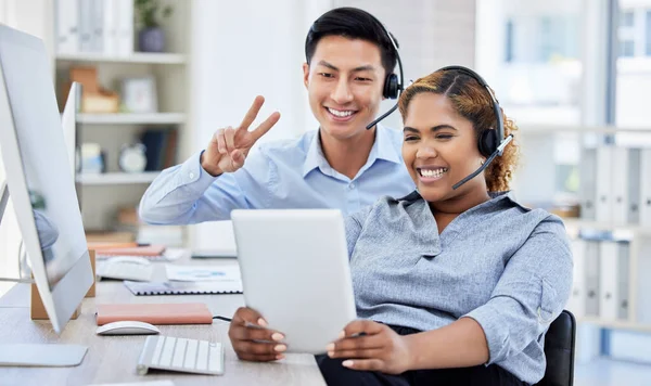 Businesspeople taking a selfie with a tablet. Customer service operators taking a photo. Sales rep taking a selfie with his colleague. Businessman making peace sign. Diverse IT support agents.