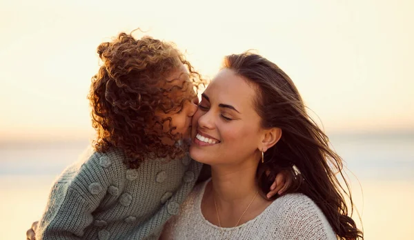Loving mixed race mother at the beach with adorable little daughter. Mom and child enjoying beach day during summer vacation. Single mother enjoying quality time with her daughter against copyspace.