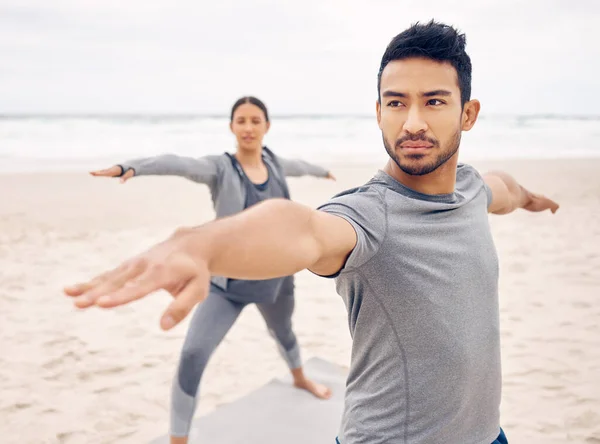 提升情绪和精神清晰度 一对年轻的运动型情侣在海滩上一起练瑜伽的时候摆姿势 — 图库照片