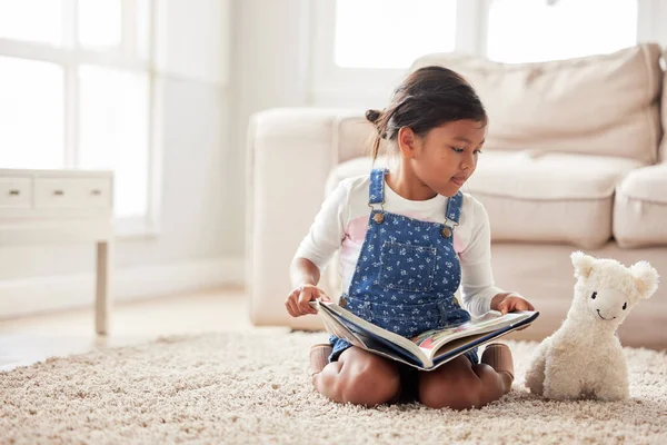 Dívka Hraje Předstírat Čtení Knihy Její Hračku Zatímco Sedí Doma — Stock fotografie