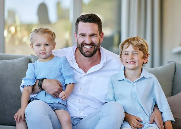 My kids are all I need. Cropped portrait of a handsome mature man sitting on the sofa at home with his son and daughter