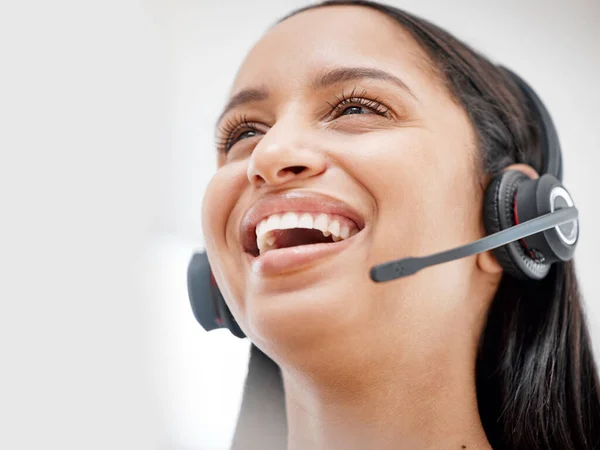 One young hispanic happy and cheerful female call center agent wearing a headset and working in customer service at work. Face of a hispanic woman answering calls working at a call center.