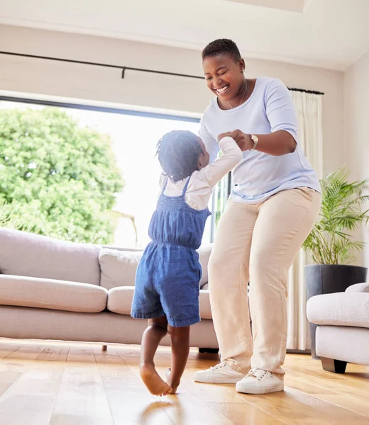 Showing off her moves. a mother and daughter dancing in the lounge at home