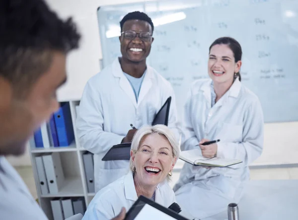 研究室で仕事を議論する研究室のコートで笑っている若い医師の多様なチーム — ストック写真