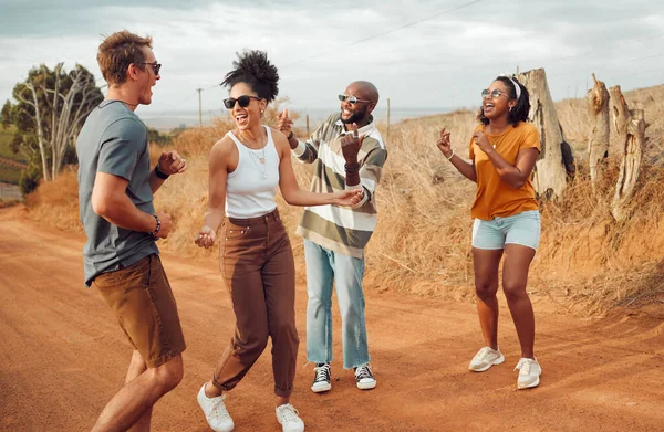 Friends, dance and nature with a man and woman group having fun outdoor during travel or adventure together. Summer, vacation and freedom with young people dancing on a sand road in the desert.