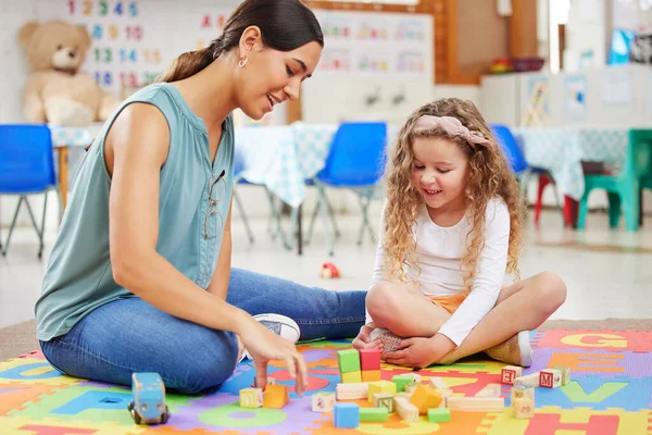 年幼的母亲和女儿在幼儿园玩五彩缤纷的玩具 一个微笑的老师用玩具块教一个学生 快乐的高加索小孩在幼儿园玩塑料玩具 — 图库照片