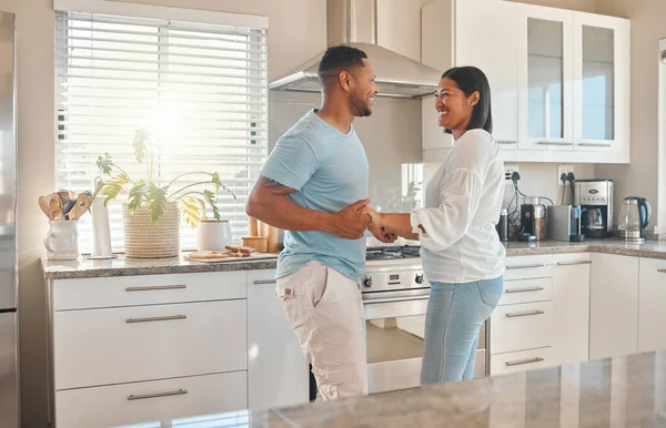 I love the way he makes me feel. a couple sharing a dance while in the kitchen at home