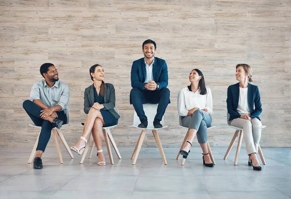 No one deserved it better than he did. Full length shot of a handsome young businessman sitting with his colleagues while being the chosen candidate