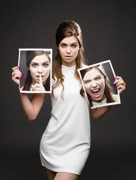 Which me do you want to meet. Studio shot of an attractive young woman dressed up in 60s wear and holding photographs of herself whispering and screaming against a dark background