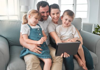 Aile olarak hatıra edinmeyi seviyoruz. Evde dijital tablet kullanan genç bir aile.