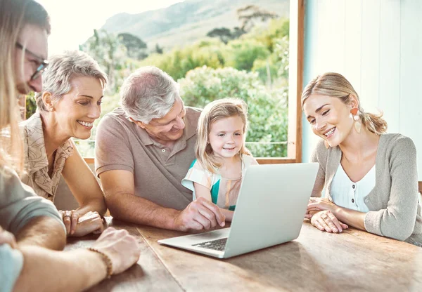 Picking the family movie. a family sitting together and using a laptop