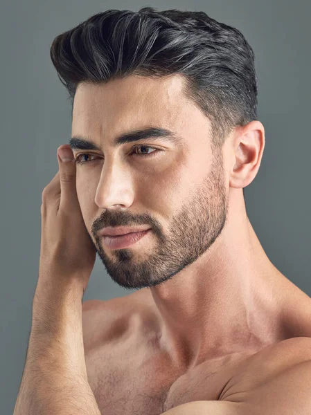 Theres no doubt that a good haircut makes us feel better. a handsome young man posing against a grey background