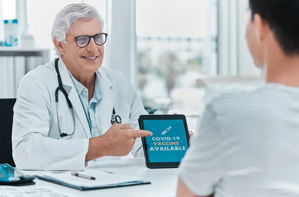 This Covid vaccine will save you in the long run. a mature doctor sitting with his patient and using a digital tablet to discuss the availability of the Covid vaccine