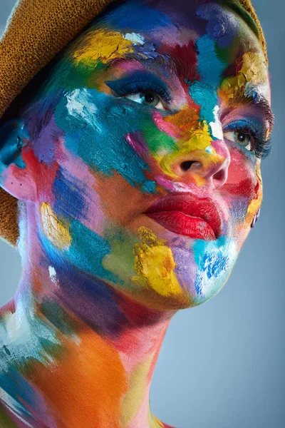 艺术家的想法往往是通过颜色来表达的 演播室拍摄的一个年轻女子脸上涂满了彩绘的照片 — 图库照片