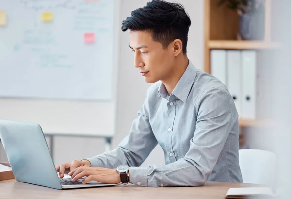 Programmer, laptop and software engineer working, coding and typing up cyber security data on the internet. Digital, web design and young Asian businessman busy with an email message in an office.