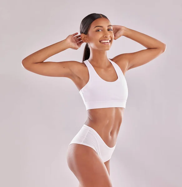 Young and sporty woman in underwear posing on white studio