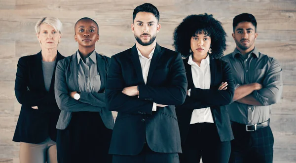 Get up and go to work. a group of businesspeople standing with their arms crossed in an office at work