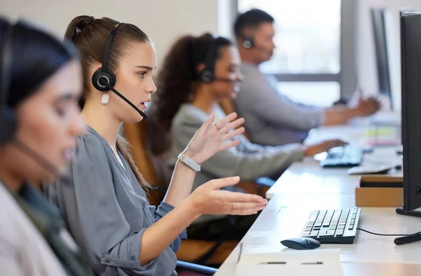 Effective communication is essential to improve the call centre experience. a young call centre agent working alongside her colleagues in an office