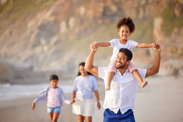 The family is the link to our happiness. a beautiful young family of three spending the day together at the beach