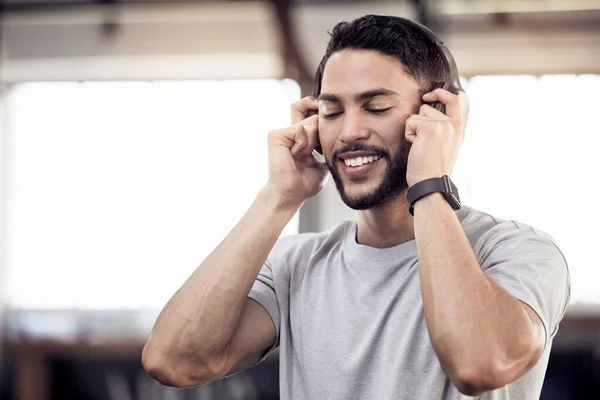 Do what you are afraid to do. a young man listening to music in gym