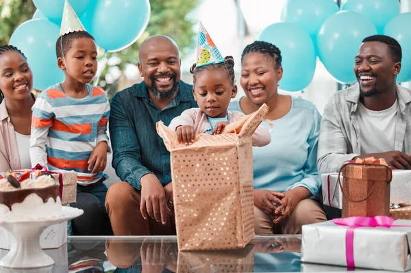 Shes excited to open all her gifts. a little girl opening gifts at her birthday party