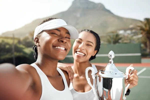 看看我们的获奖者 两名年轻的女运动员在网球场上拿着奖杯自拍的肖像 — 图库照片