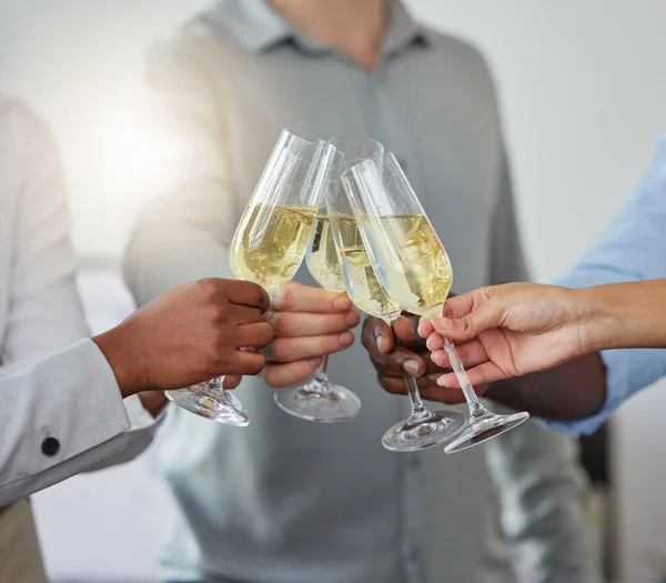 Forget the year with a glass of cheer. a group of unrecognizable colleagues having a celebratory drink in an office