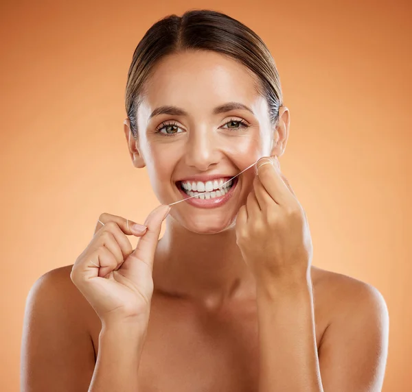 Woman, dental flossing and teeth with smile for clean hygiene and health against a studio background. Portrait of a happy toothy woman smiling in beauty floss for hygienic mouth, oral and gum care.