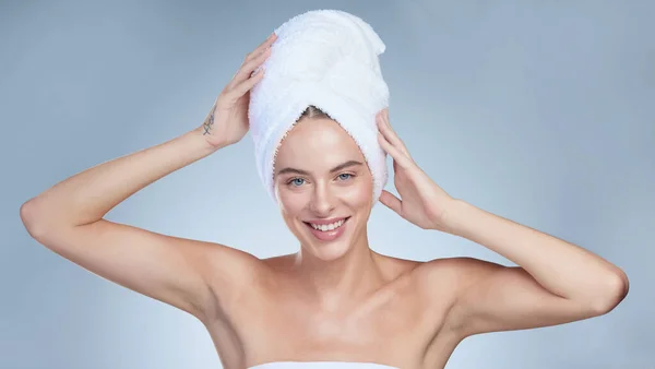 シャワーを浴びて スタジオポートレートの魅力的な若いです女性ポージングで彼女の頭の上にタオルでグレーの背景 — ストック写真