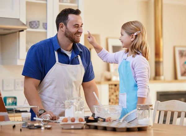 你真有趣 一个年轻的父亲和女儿一边烘烤一边玩耍 — 图库照片