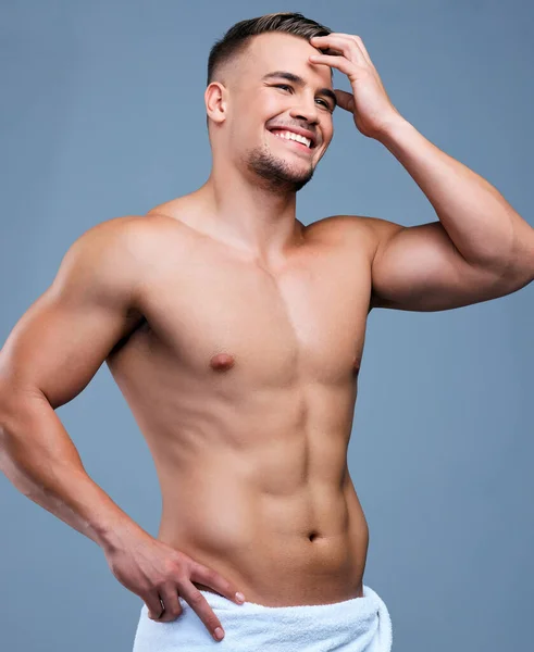 有点害羞的肌肉 一个肌肉发达的年轻人站在一条灰色背景的毛巾上的演播室照片 — 图库照片