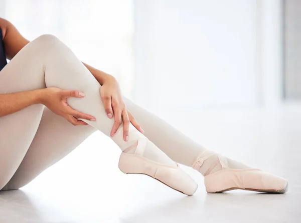 The perfect fit shoes play a role in injury prevention. a young ballerina holding on to her leg