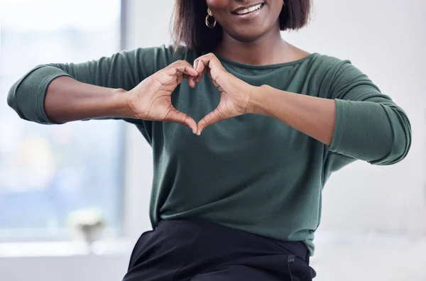 Were not just a business, were a company with heart. an unrecognisable businesswoman making a heart shaped gesture with her hands in a modern office