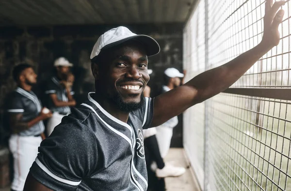 Baseball, training and portrait of coach in dugout, smile, relax and happy about sports vision, goal and mission. Sport, stadium and cheerful team trainer watching game with baseball player group.