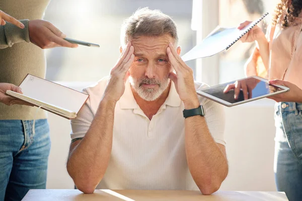 Stuck in a dance of collapsing walls. a mature businessman looking stressed and frustrated in a meeting at work