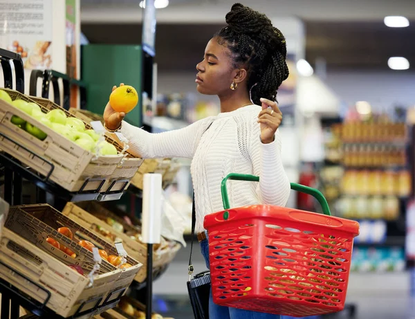 생산물을 선택하는 차이를 가져온다 여자가 식품점의 농산물 코너를 둘러보고 — 스톡 사진