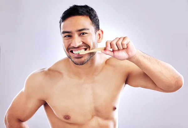 Very few of us brush our teeth as well as we could. Studio shot of a handsome young man brushing his teeth