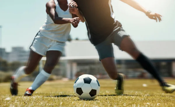 Football, sports and team legs in game on a field while passing, touching and running with a ball. Active, fast and skilled soccer players in a competitive game with workout on a sport pitch outdoors.