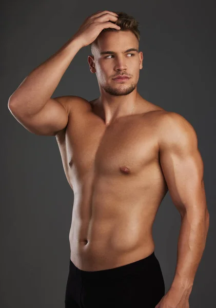 终极健身模型 一个英俊而有运动精神的年轻人 在黑暗的背景下 赤身裸体地在演播室里摆姿势 — 图库照片