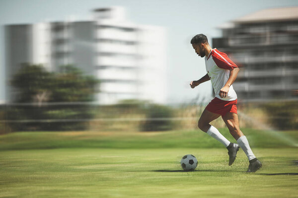 Football, fitness and soccer player running on the field to score goals in a sports match or training game outdoors. Blur, Brazil and young athlete doing cardio exercise, practice or workout on grass.
