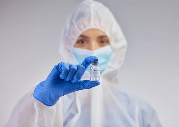 This is the most important invention of late. a female nurse holding a vaccination vial against a studio background