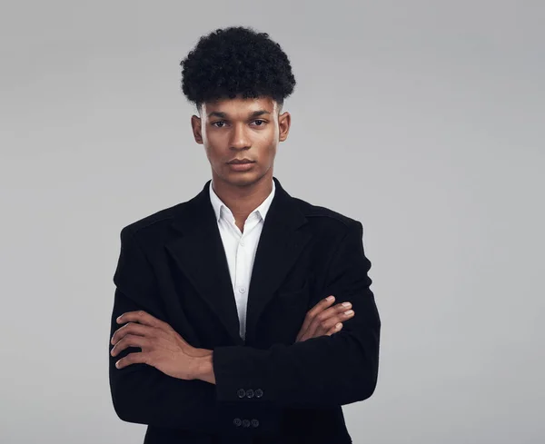 I say what I mean and mean what I say. Studio portrait of a confident young businessman posing against a grey background