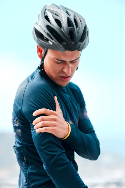 Sport, injury and arm pain with man cyclist during exercise routine outdoors, fitness, hurt and discomfort. Health, inflammation and sports injury by athletic guy holding shoulder pain after cycling.