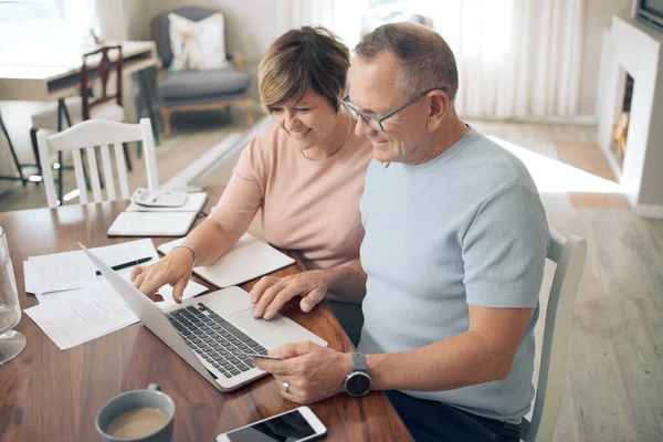 Paying off bills is so relieving. a mature couple using their bank card to digitally pay their bills