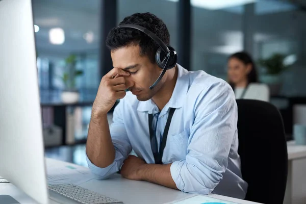 Not every call has a happy ending. a young man using a headset and looking stressed in a modern office