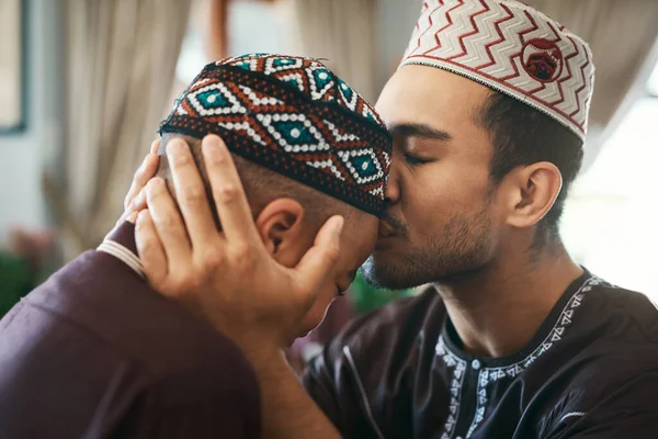 私はいつもあなたを心に留めます 若いイスラム教徒の父親が愛情を込めて息子に額のキスをし — ストック写真