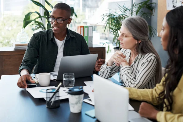 Just a steady beating heart, a wish and a prayer. a group of businesspeople brainstorming and using a laptop in a modern office