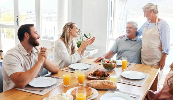 Food, relax and happy with family at table for lunch, love and smile together in dining room. Eating, holiday and dinner for celebration with couple and parents for retirement, peace and lifestyle.